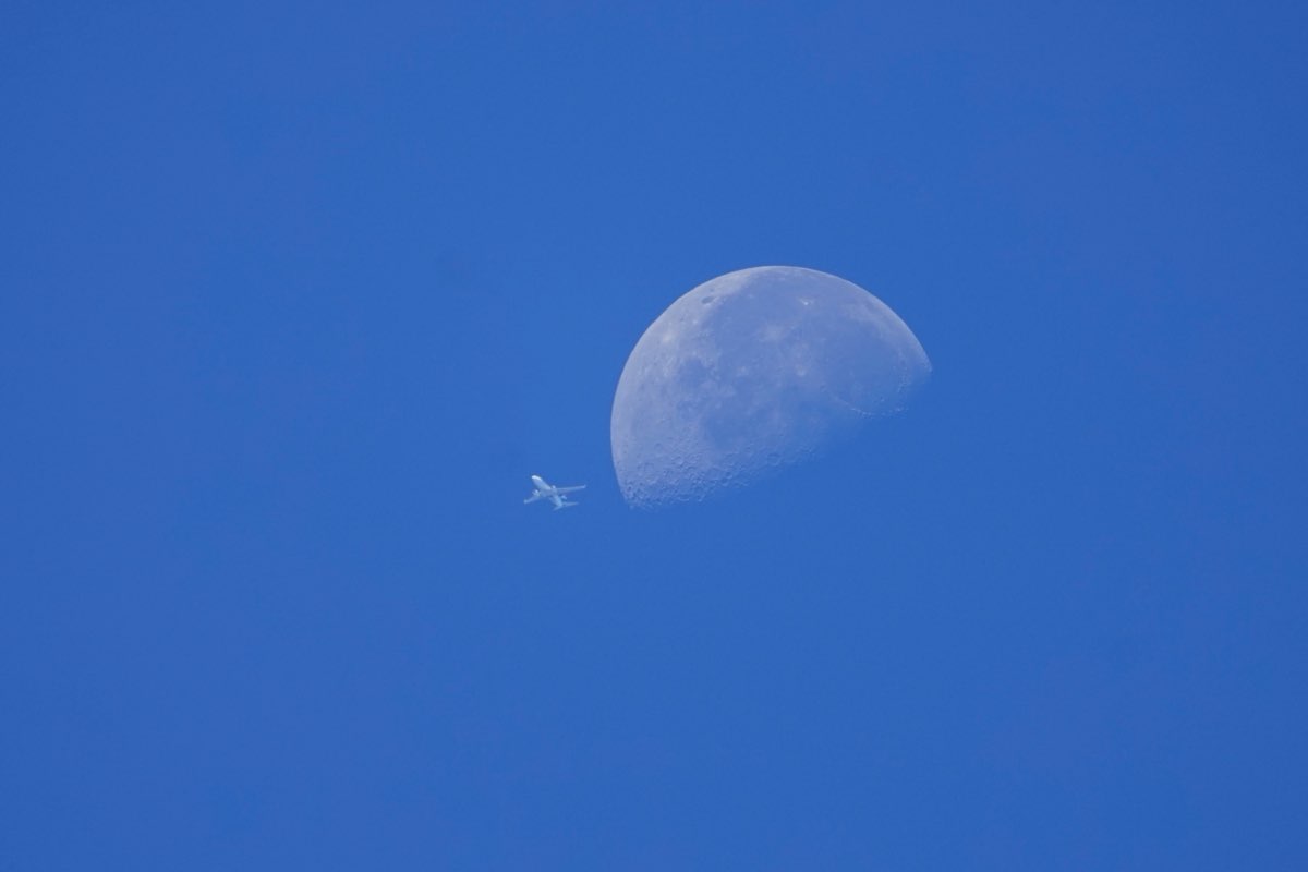Small airliner passing just left of the daytime moon